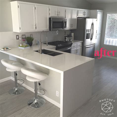 The addition of an island with waterfall countertops, to a traditional home, can look like a spaceship landed in your kitchen. After remodel. White Quartz countertop. Waterfall ...