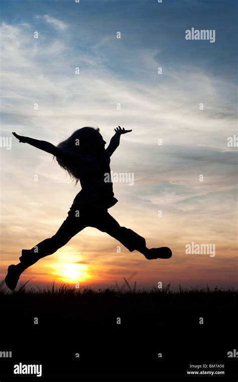 Young Girl Energetically Having Fun Jumping Around Silhouette Stock