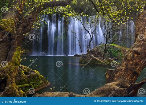 Beautiful Waterfalls Framed In Trees Over Emerald Water In Deep Green