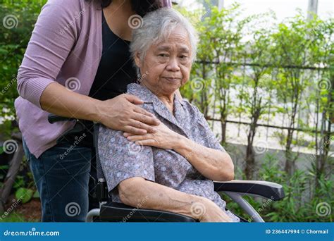 Caregiver Daughter Help Asian Senior Or Elderly Old Lady Woman On Electric Wheelchair In Park