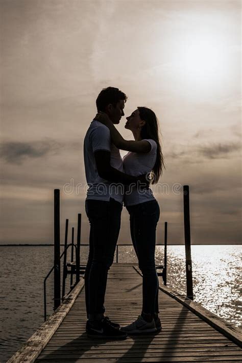 Silhouette Photo Of Romantic Couple Enjoying Sunset Harbor View Stock