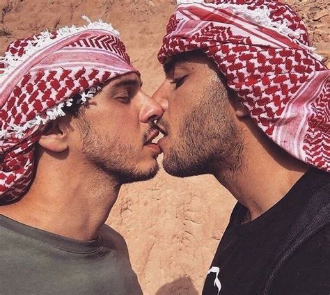 Two Men With Heads Coverings Kissing Each Other