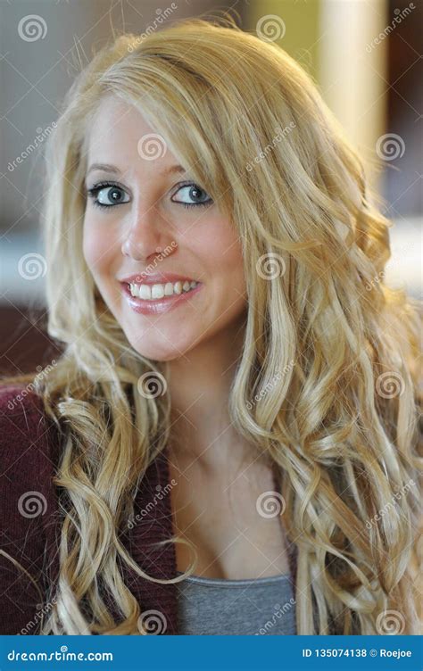 Color Photo Of A Beautiful Young Blonde Woman With Big Blue Eyes