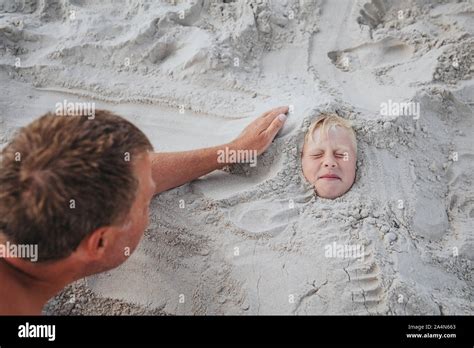 Boy Buried In Sand Stock Photo Alamy