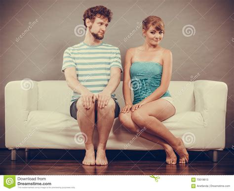 Shy Woman And Man Sitting Close To Each Other On Couch Stock Image