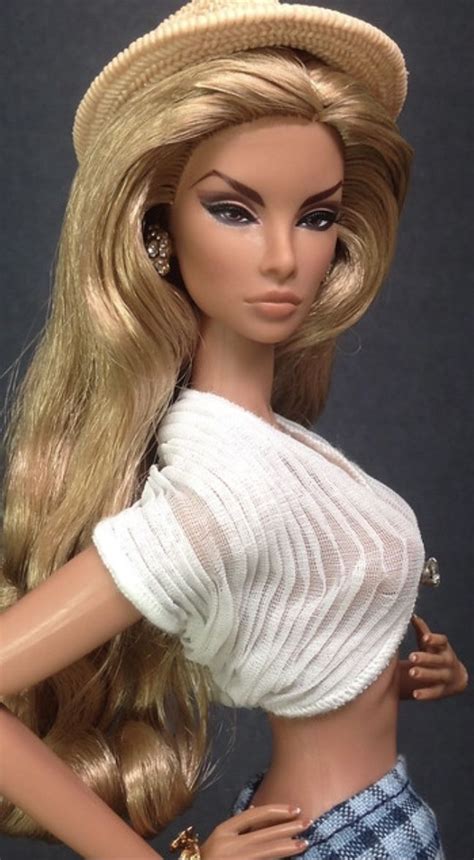 A Barbie Doll With Long Blonde Hair Wearing A White Top And Blue Plaid