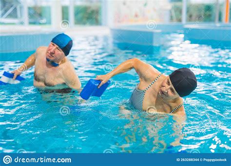 Active Pensioners At A Swimming Pool Doing Aqua Fitness Exercises With