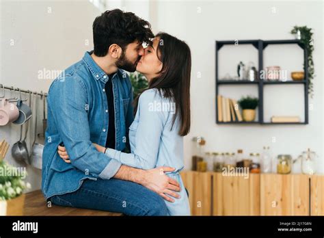 Affectionate Couple Kissing Each Other In Kitchen Stock Photo Alamy