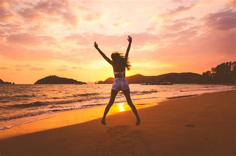 Premium Photo Traveler Woman Jumping On Beach At Sunset