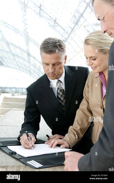 Three Business People Signing Document Stock Photo Alamy
