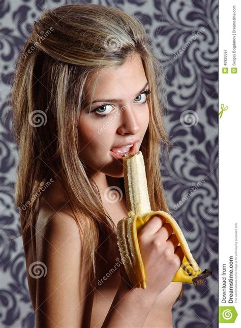 A Beautiful Babe Woman Holding A Banana In Her Hand And Looking At The