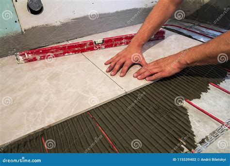 Ceramic Tiles And Tools For Tiler Worker Hand Installing Floor Stock