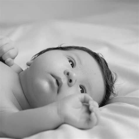 Newborn Baby In A Wrap On White Blanket Beautiful Portrait Of Little