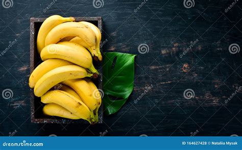 Bananas On A Black Wooden Surface Tropical Fruits Top View Stock