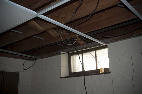 Dropped ceilings make the space feel more closed in as the ceilings are a bit lower than they need to be and can look like more of a mobile home, hospital or office and not like your basement topic's. The Organized McTatty: Basement Drop Ceiling is Down