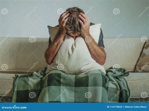 Young Sad And Desperate Man At Home Sitting At Sofa Couch Covering Face