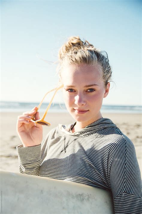 Young Surfer Girl Holding Sunglasses And Looking At The Camera Del
