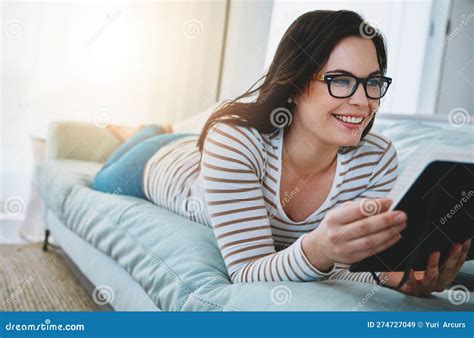 When Shes Reading Shes Relaxing A Young Woman Relaxing On The Sofa And Reading A Book At Home