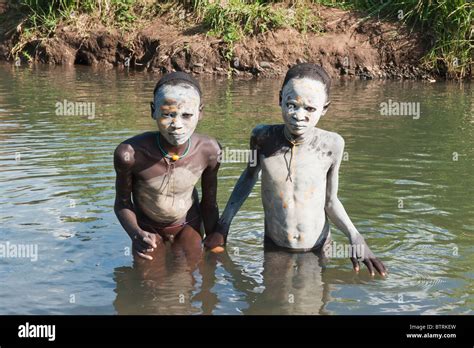 Zwei Surma jungen mit Körper Gemälde in den Fluss Kibish Omo River