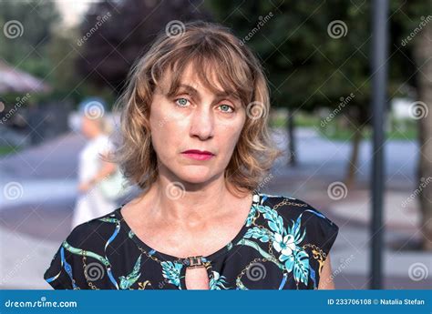 portrait of a beautiful mature woman of middle age 50 years old with blond hair with a pensive