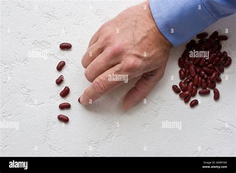 Hand of a businessman counting kidney bean Stock Photo - Alamy