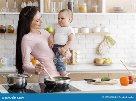 Mother Cooking Lunch With Baby At Kitchen Stock Image Image Of Infant Millennial