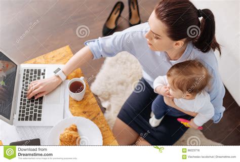 Inventive Contemporary Mom Multitasking In The Morning Stock Photo