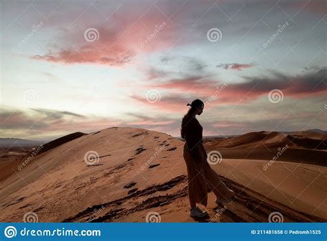 Woman Silhouette On The Highest Dune In The Sahara Desert At Sunset