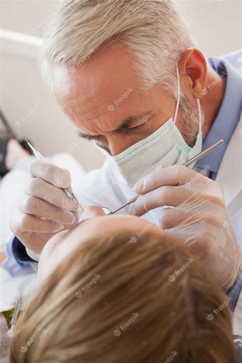 Dentista Examinando Los Dientes De Un Paciente En La Silla De Los
