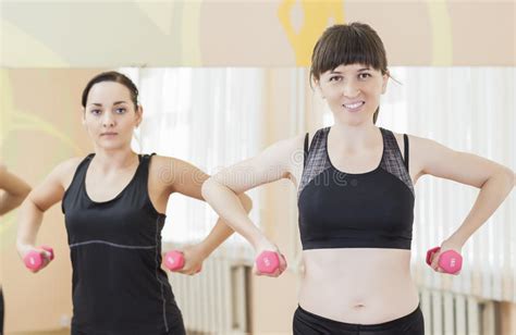 Two Smiling Caucasian Sports Women Exercising With Barbells Indoors