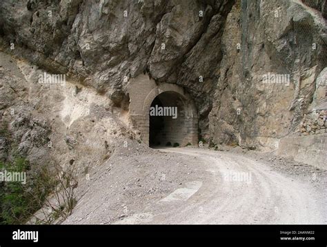 A Small Tunnel Dug Into The Rock On A Dirt Road In The Alps What