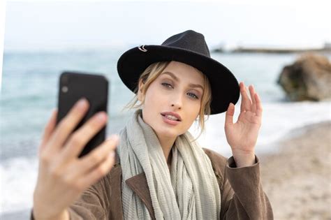 premium photo portrait of stunning female model taking a selfie using her mobile phone while