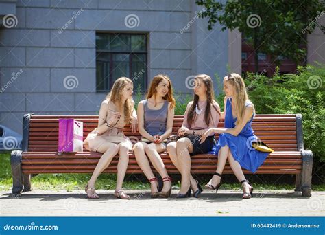 Group Of Four Young Women Sitting On Bench In Summer Park Stock Image Image Of Laughing