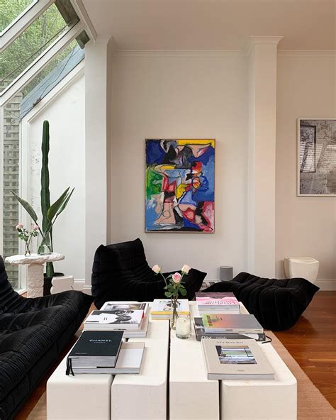 A Living Room Filled With Furniture And A Large Painting On The Wall
