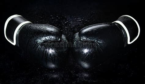 A Pair Of Black Boxing Gloves Isolated On A Dark Background Closeup
