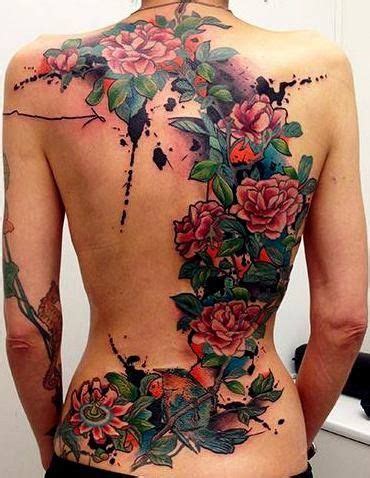 The Back Of A Woman S Body Is Covered In Tattoos With Flowers On It