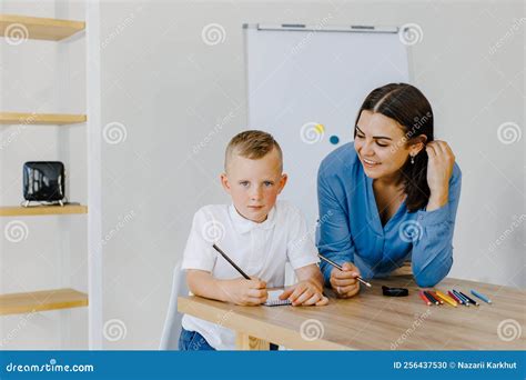Attentive Young Woman Tutor Teacher Helping Little Boy Pupil With