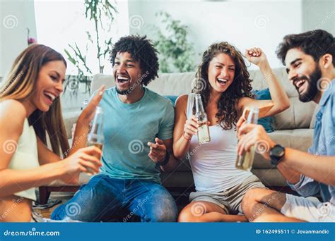 Multi Ethnic Young Friends Eating Pizza At Home And Having Fun Stock