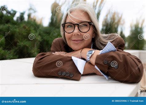 portrait of a successful well groomed pretty gray haired woman pensioner dressed in an elegant