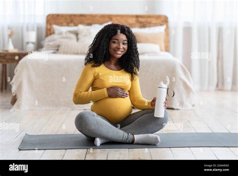 Pregnant African American Lady Drinking Water During Exercising Stock