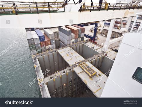 Empty Ships Cargo Holds During Container Discharge In Port Stock Photo