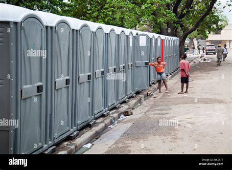 Two Children Standing By A Row Of Portable Toilets Port Au Prince