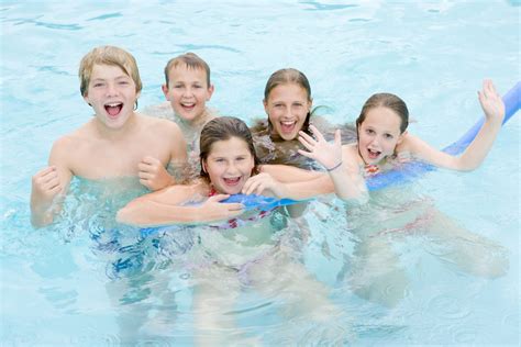 Five Young Friends In Swimming Pool Playing And Smiling Lice Clinics Of Texas