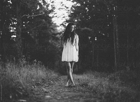 A Beautiful Young Woman Walks Alone In A Dark Woods Stocksy United