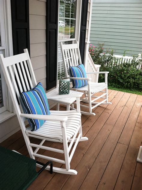 A wicker rocking chair is nostalgic and charming. White rocking chairs on front porch with summer-perfect ...