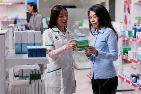 Premium Photo | Asian pharmacist explaining boxes of pills to give