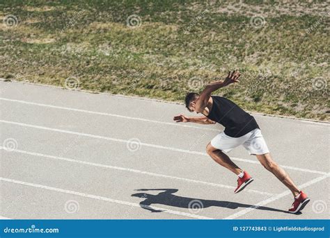 Young Male Sprinter Taking Off From Starting Position Stock Image