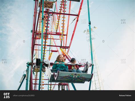Boy And Girl Riding A Ferris Wheel Stock Photo Offset
