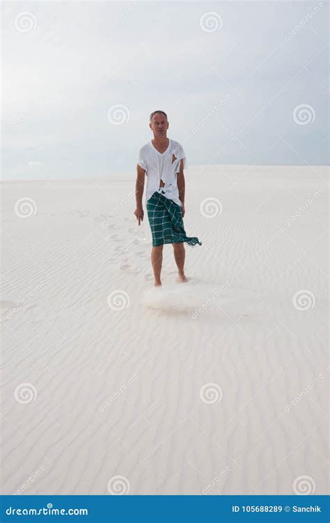 Exhausted Man Lost In The Desert Is Walking Along The Dune Stock