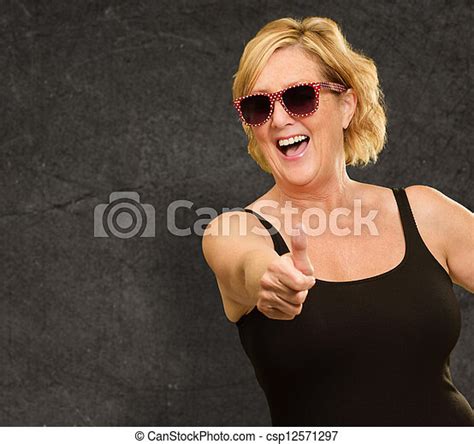 Mature Woman Showing Thumbs Up Sign On Wall Canstock